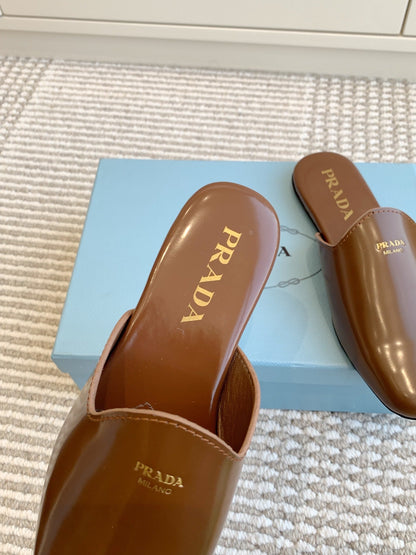 PRADA MULES IN BROWN GLOSSY SHEEPSKIN GOLD LETTERING LOGO