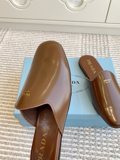 PRADA MULES IN BROWN GLOSSY SHEEPSKIN GOLD LETTERING LOGO
