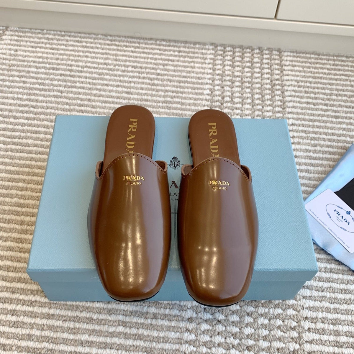 PRADA MULES IN BROWN GLOSSY SHEEPSKIN GOLD LETTERING LOGO