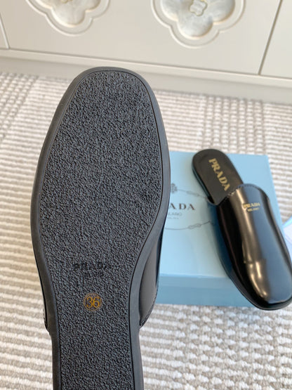 PRADA MULES IN BLACK GLOSSY SHEEPSKIN GOLD LETTERING LOGO