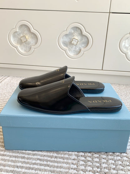 PRADA MULES IN BLACK GLOSSY SHEEPSKIN GOLD LETTERING LOGO