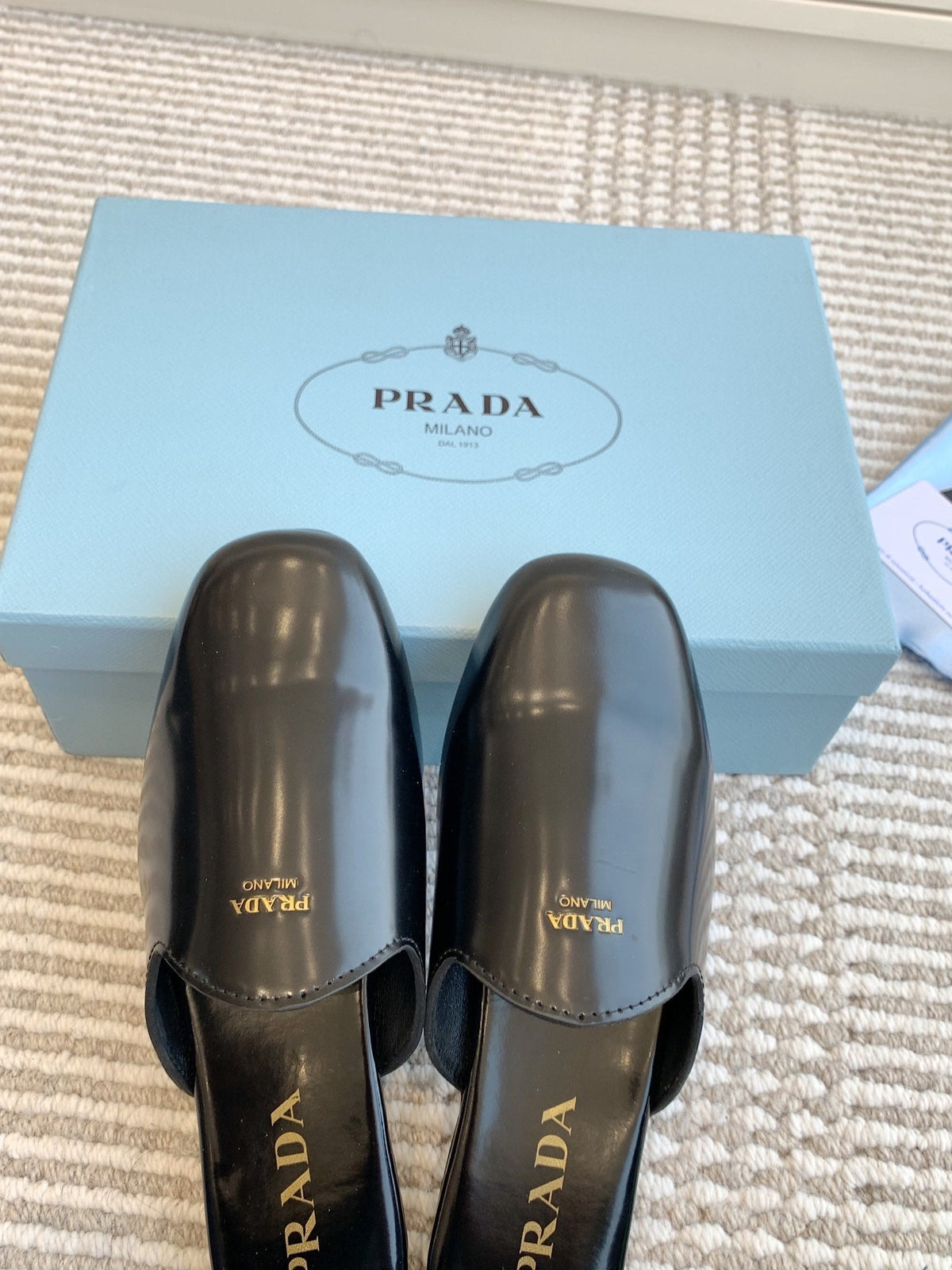 PRADA MULES IN BLACK GLOSSY SHEEPSKIN GOLD LETTERING LOGO