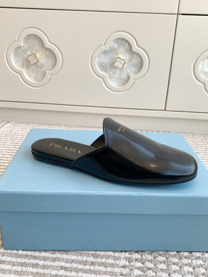 PRADA MULES IN BLACK GLOSSY SHEEPSKIN GOLD LETTERING LOGO