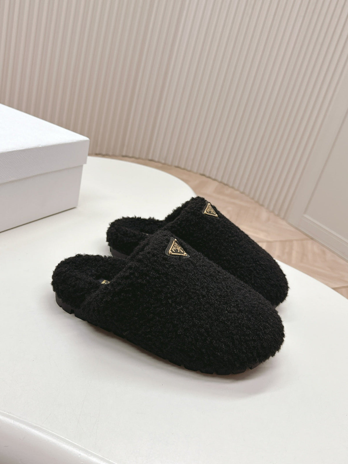 PRADA MULES ATTACHED TRIANGLE LOGO IN BLACK SHEARLING
