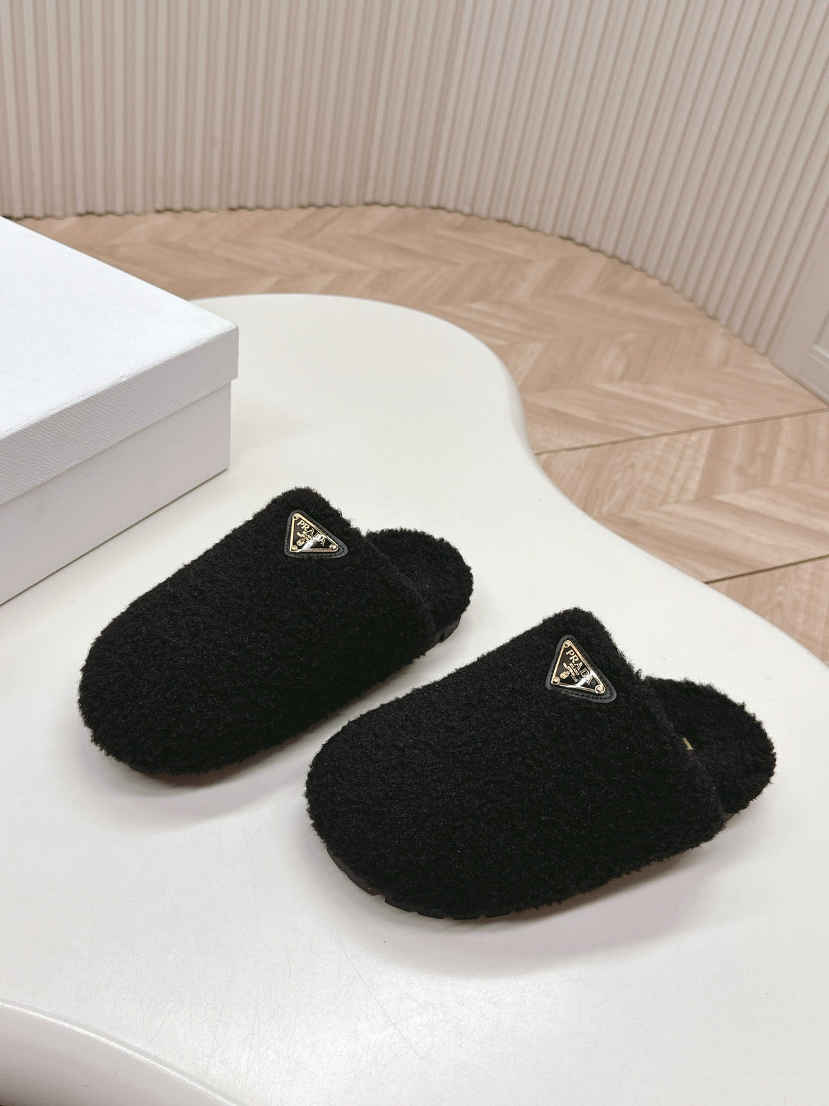 PRADA MULES ATTACHED TRIANGLE LOGO IN BLACK SHEARLING