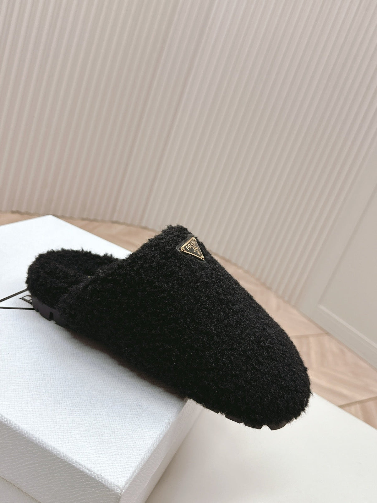 PRADA MULES ATTACHED TRIANGLE LOGO IN BLACK SHEARLING