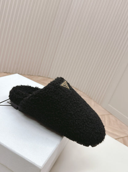 PRADA MULES ATTACHED TRIANGLE LOGO IN BLACK SHEARLING