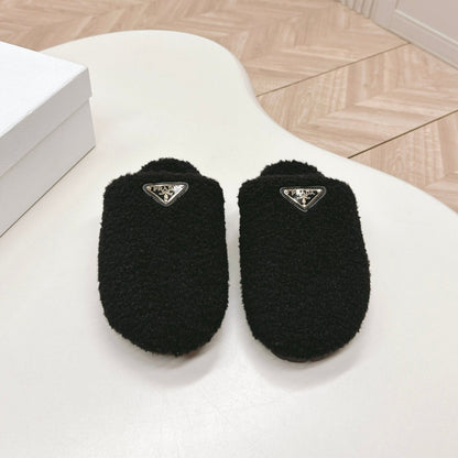 PRADA MULES ATTACHED TRIANGLE LOGO IN BLACK SHEARLING