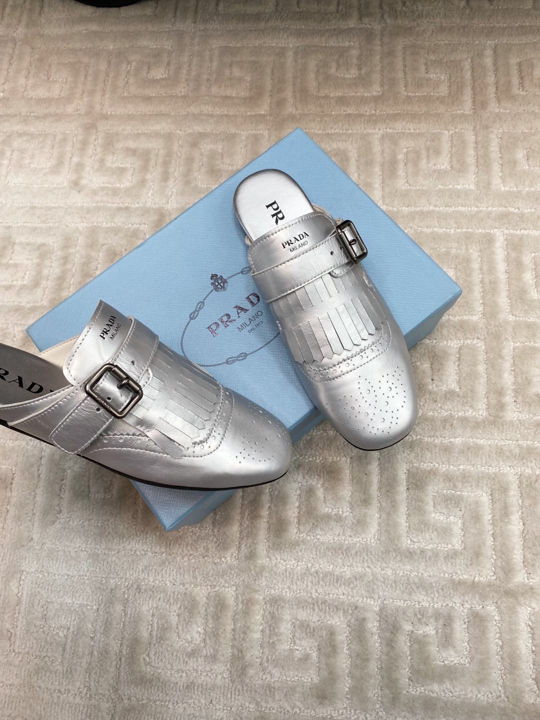 PRADA TASSEL MULES IN SILVER METALLIC LAMBSKIN